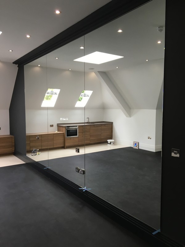 Frameless glass partition in loft conversion by Manor Park glaziers