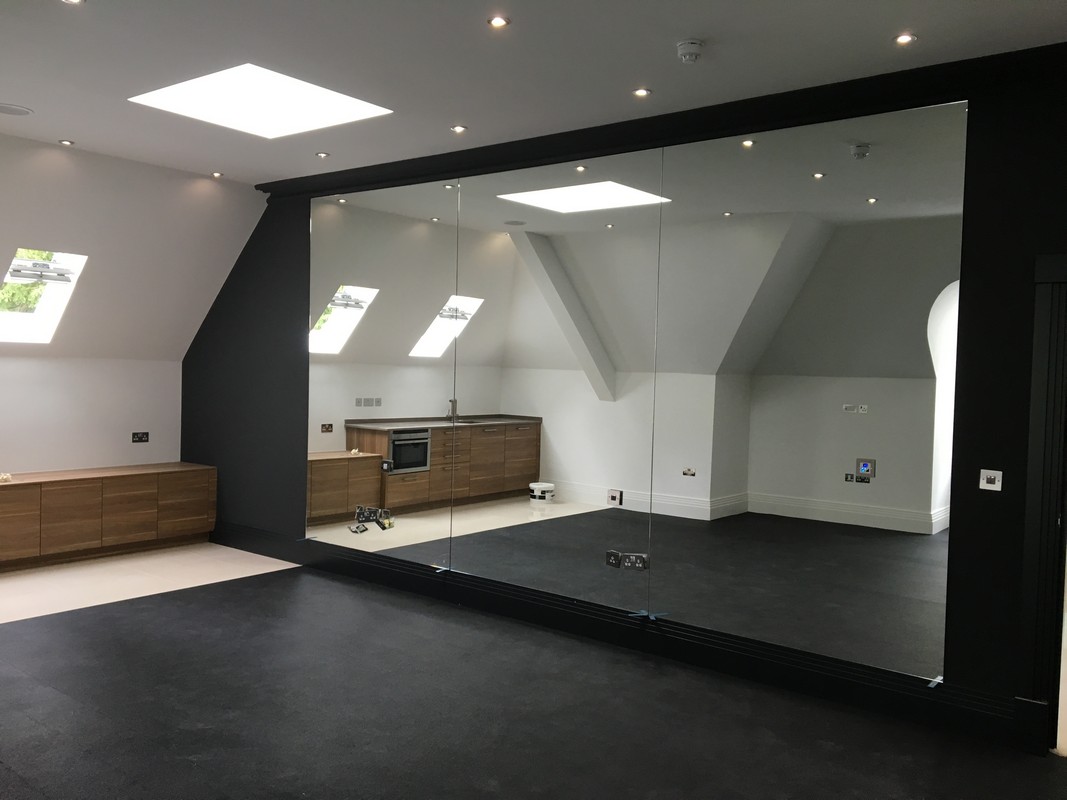 Frameless glass wall dividing loft conversion in Manor Park